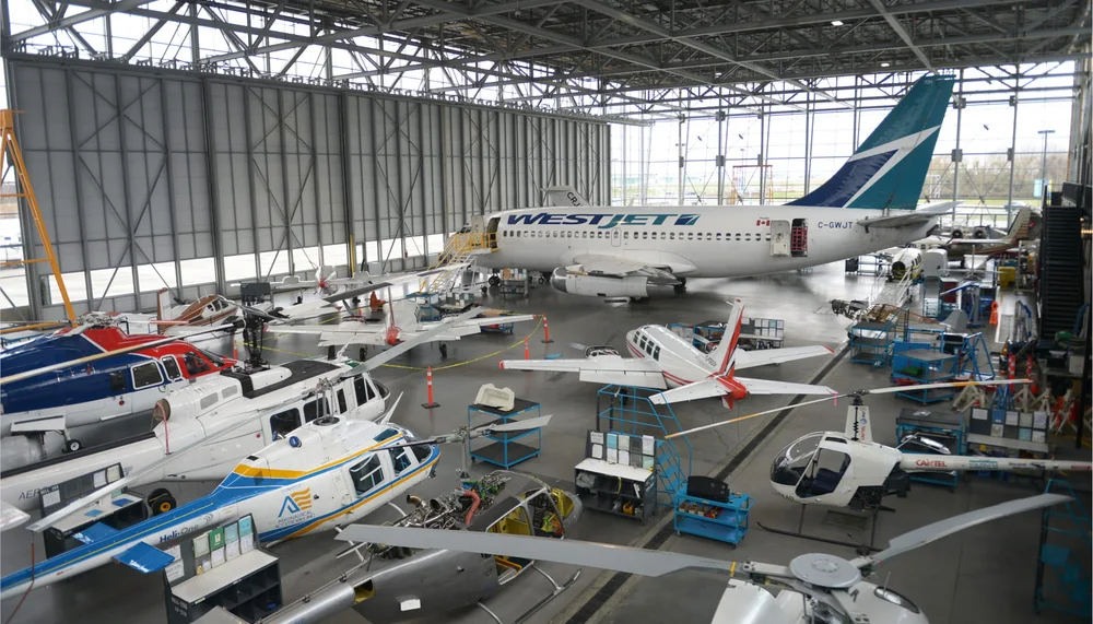 A maintenance hangar with jets and smaller aircraft